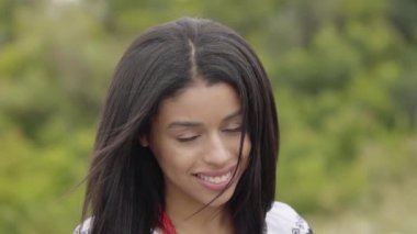 Portre güzel kendine güvenen kaygısız Afro-Amerikan kız kameraya bakarak. Boş zaman ve açık havada zevk oldukça bağımsız gülümseyen genç bir kadının hafta sonu. Gerçek insanlar serisi. Yavaş çekim.