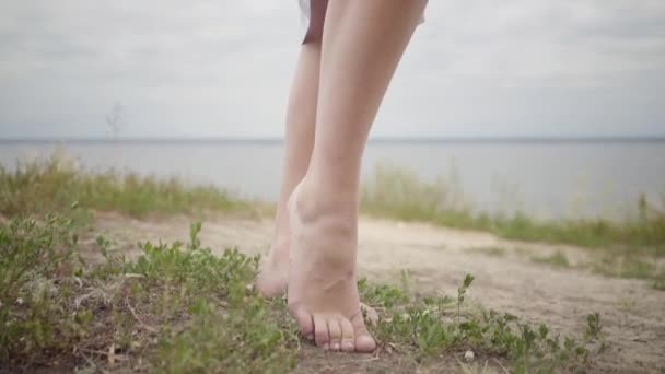 Belle fille pieds nus insouciante portant une longue robe de mode d'été regardant avec confiance la caméra profiter des stands sur le terrain. Loisirs et week-end d'une jolie jeune femme en plein air. Série des personnes réelles . — Video