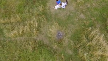 Göl veya nehir yakınında yürüyen uzun yaz moda elbise giyen üç kız hava görünümü. İki Beyaz ve bir Afro-Amerikan kız boş zamanlarını dışarıda geçiriyorlar. Drone çekim.