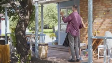 Genç mutlu adam ve kadın eski evin verandada gülümseyerek dans. Sevimli çift birlikte eğleniyor. Evde boş zaman. İhale ilişkisi.