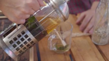 Retro bluz ve etek genç kadın masada oturan kocasına sıcak çay döküyor. Karı koca arasındaki ilişki. Mutlu rutin bir hayat. Vintage tarzı