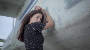 Mutlu genç gülümseyen esmer kız modeli büyük beyaz düzlemin yakınındaki kameraya bakarken poz. Yaz. Seyahat insebunu. Seyahat kavramı, uçak, hafta sonu
