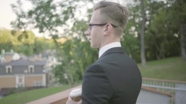 Terasta kahve yle duran başarılı işadamı. Ofis yöneticisi doğaya hayran açık havada dinlendirici. Ofis yaşam tarzı, mola süresi, konforlu işyeri