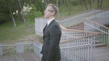 Çekici ve kendine güvenen genç işadamı resmi bir takım elbise bir toplantı ya da sokakta bir anlaşma için bir ortak veya sponsor bekliyor