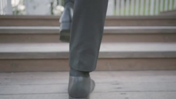 Πόδια ενός κομψού καλά ντυμένους επιχειρηματία με ακριβά κουστούμια και παπούτσια να περπατούν πάνω. Τρόπος ζωής γραφείου, επιχειρηματική έννοια. Ο άντρας με το κουστούμι που περπατάει έξω. Αναρρίχηση σκάλες. — Αρχείο Βίντεο