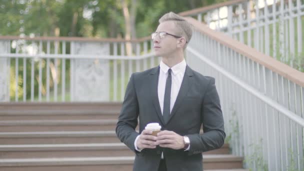 Retrato joven ambicioso empresario exitoso de pie en la escalera del parque beber café. El gerente de la oficina relajándose admirando al aire libre. Estilo de vida de oficina, tiempo de descanso, lugar de trabajo cómodo . — Vídeos de Stock