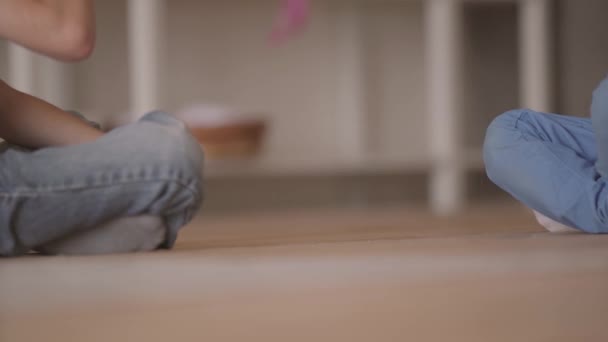 Dois garotos não reconhecidos sentados no chão brincando com o carrinho de brinquedo sentado no chão em casa. Os irmãos passam tempo em casa. Família feliz, infância despreocupada . — Vídeo de Stock