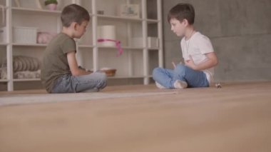 İki sevimli kardeşler evde yerde oturan oyuncak araba ile oynarken katta oturuyor. Kardeşler evde vakit geçiriyorlar. Mutlu aile, kaygısız çocukluk.