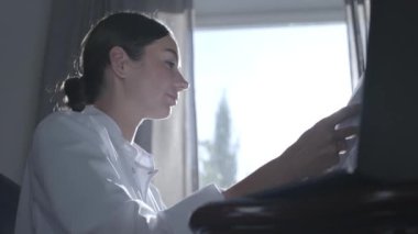 Profesyonel kadın doktor ofisinde bir pencere ve güneş ışığı arka plan karşı bir masada otururken kağıtları bakıyor. Meslek, tıp ve sağlık kavramı.