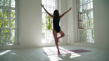 Sağlıklı beyaz beyaz kız yoga pratik beyaz büyük odada paspas üzerinde duruyor. Genç kadın kapalı fitness egzersiz. Genç bir kadın evde egzersiz yapmaktadır. Sağlıklı yaşam tarzı