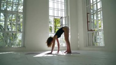İnce beyaz kadın yoga pratik büyük odada paspas üzerinde duruyor. Güzel kadın evde egzersiz yapmaktadır. Sağlıklı yaşam tarzı.