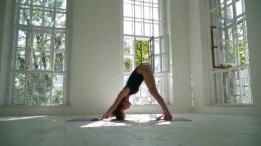 Sevimli becerileri beyaz kadın yoga pratik büyük odada paspas üzerinde duran. Güzel kadın evde egzersiz yapmaktadır. Sağlıklı yaşam tarzı.