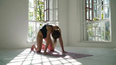 Becerileri sağlıklı kızıl saçlı beyaz beyaz kadın beyaz büyük odada paspas üzerinde yoga pratik. Spor giyim genç kadın kapalı fitness egzersiz.