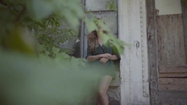 Eski binada duran genç ve güzel bir kadının portresi. Yaz, kadınlık, dinlenme günü kavramı. Gerçek insanlar serisi.