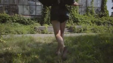 Kendine güvenen güzel genç kadının geri görünümü kaçan ve daha sonra dönüm ve yeşil yaz parkı kamera bakarak. Yaz lık, kadınlık, dinlenme, kaygısız yaşam kavramı
