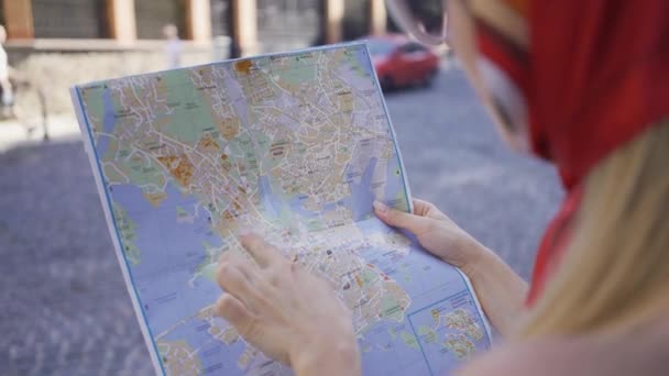 Woman standing on the street with the map in hands. Girl trying to find a way in the old European city. Tourism concept, vacation. — Stock Video