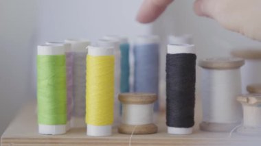 Dikiş için iplik seçimi kadın el yakın çekim. Kadın sarı ipliklerden bir makara alıyor. İş, meslek, hobi kavramı