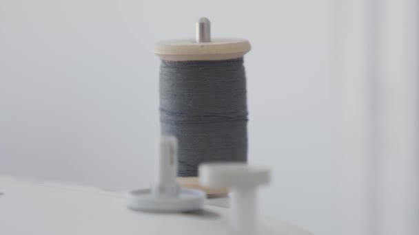 Close-up of a spool of thread spinning on a sewing machine while the work is in process. Concept of job, profession, hobby. Clothes design. Manufacturing — Stock Video