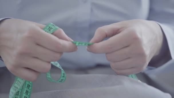 Close-up of unrecognizable woman working with the meter, measuring the distance before sewing clothes. Concept of job, profession, hobby — Stock Video