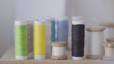 Dikiş için iplik seçimi kadın el yakın çekim. Kadın sarı ipliklerden bir makara alıyor. İş, meslek, hobi kavramı. Yavaş çekim.