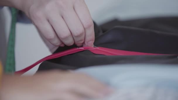 바느질 하기 전에 핀으로 직물에 지퍼를 고정 하는 여성 재봉사의 클로즈업 핸드. 직업, 직업, 취미의 개념 — 비디오