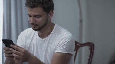 Portre genç hipster adam akıllı telefon ve kıvırcık kız tatilde stüdyoda rahatlatıcı latte içme mesaj yazarak