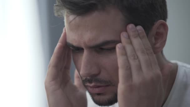 Ritratto di un giovane che si sfrega la testa con le mani. Stress o cefalea . — Video Stock