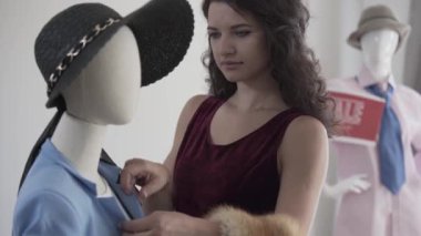 Showroom veya stüdyoda şapka ile manken genç güzel kadın moda satıcısı veya stilist uydurma gömlek veya blazer Portresi