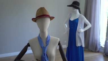 Showroom veya dükkanda duran şık giyim, aksesuar ve giyim üzerine oturan kadın mankenler.