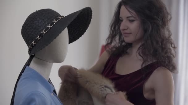 Belle vendeuse mettant de la peau de renard sur l'épaule d'un mannequin dans la boutique exclusive de vêtements. La femme habiller mannequin dans des vêtements élégants — Video