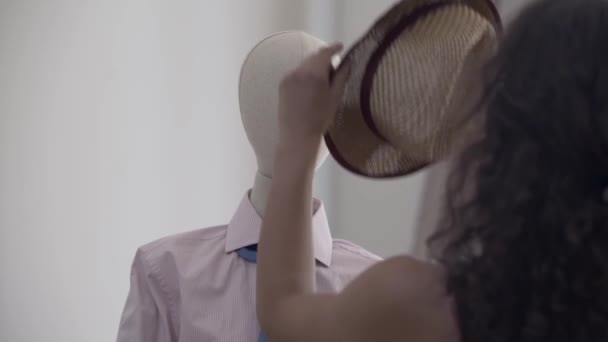 Mujer poniendo sombrero en la cabeza del maniquí . — Vídeos de Stock
