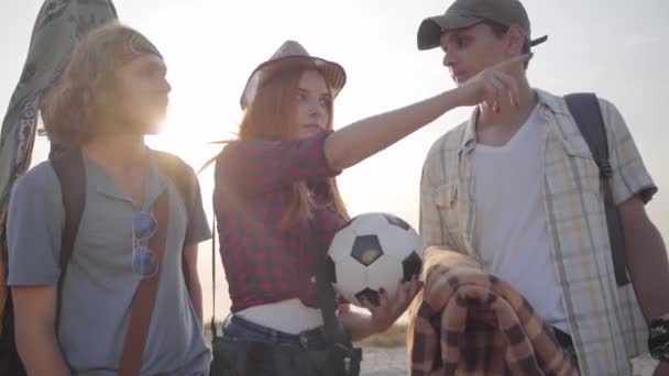 Jóvenes amigos llegaron a la playa con la guitarra y la pelota de fútbol en la noche de verano para relajarse y divertirse — Vídeos de Stock