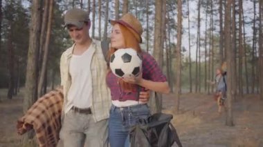 Genç hipster arkadaşlar Grubu dinlenmek ve eğlenmek için yaz akşamı gitar ve futbol topu ile plaja geldi