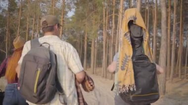 Genç arkadaşlar grubu dinlenmek ve eğlenmek için yaz akşamı gitar ve futbol topu ile plaj veya ormana geldi