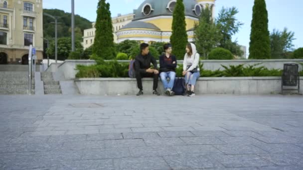 Muž s jednou nohou na berlích, který cvičím se skateboard na pozadí, zatímco se na něj lidé dívají na pozadí. Tělesně postižení se jezdí na skateboard. Motivace, aktivní životní styl. — Stock video