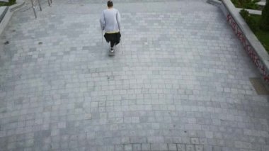 Koltuk değneği eğitim ve sokakta hileler yapıyor bir bacak ile adam üst görünümü. Engelli kişi kaykay abin. Motivasyon, aktif yaşam tarzı, asla vazgeçme