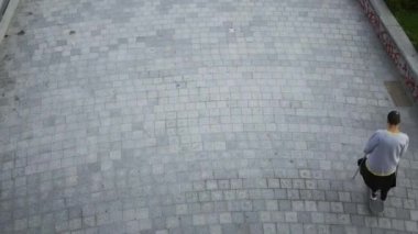 Koltuk değnekleriyle kaykayını daireler çizen adamın en iyi görüntüsü. Engelli kişi bir kaykay ile eğitim. Motivasyon, aktif yaşam tarzı, asla vazgeçme