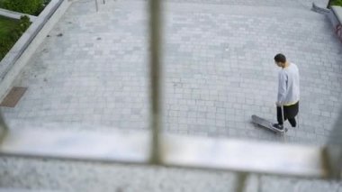 Koltuk değnekleriyle bir bacağı olan genç adamın üst ünü kaykayını daireler çizerken. Engelli kişi bir kaykay ile eğitim. Motivasyon, aktif yaşam tarzı, asla vazgeçme