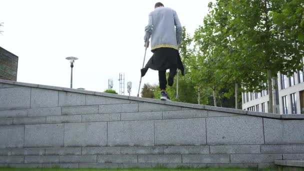 Hombre hábil con una pierna en muletas haciendo volteretas en la calle. Personas discapacitadas entrenando y haciendo trucos. Motivación, estilo de vida activo, nunca te rindas — Vídeos de Stock