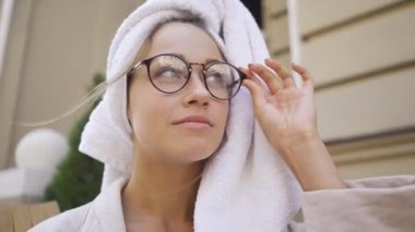 Portre gözlüklü ve başında havlu ile genç kadın gülümseyen açık havada. Kendine güvenen kız açık havada güzel bir sabah zevk. Serbest.