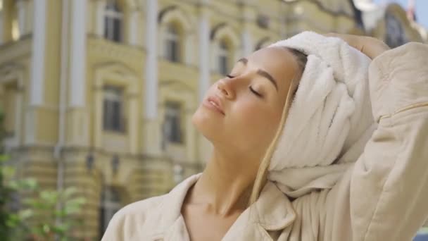 Portrait smiling young woman taking off the towel from her hair and drying it smiling happily while standing on the street. Confident girl enjoying a beautiful morning outdoors — Stock Video