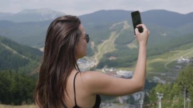 Güzel manzara önünde duran selfie çeken güzel genç kadın. Vahşi doğayla bağlantı. Boş zaman, aktif yaşam tarzı. Turizm, seyahat