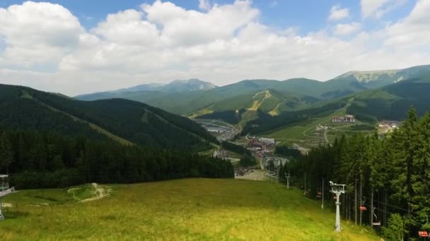 Beautiful mountain landscape. Small tourist town hiding among forest and mountains. Connection with nature. Traveling, tourism, vacation. Sunny day. Drone shooting — 图库视频影像