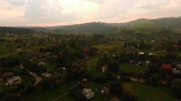 Letecký pohled na malou moderní turistickou vesnici skrývající se mezi horami. Souvislost s přírodou. Cestování, Turistika, dovolená. Za slunečného dne. Drone, pohled shora — Stock video