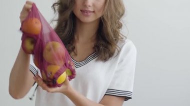 Genç ince kadın modern mutfakta masaya bir çanta elma dökme. Sağlıklı gıda kavramı. Nutri terapisti, nutraceutical, beslenme uzmanı, sağlıklı yaşam koçu mesleği