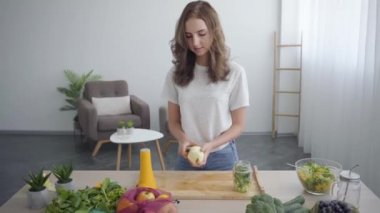 Güzel genç ince kadın mutfakta masada duran keskin bıçak ile elma soyma. Sağlıklı gıda kavramı. Nutri terapisti, nutraceutical, beslenme uzmanı mesleği