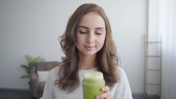 Portrait of young smiling woman smelling smoothie in the shaker in the kitchen at home. Concept of healthy food. Profession of nutri therapist, nutraceutical, nutritionist, wellness coach — Stock Video