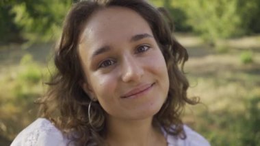 Kameraya bakan kıvırcık saçlı pozitif genç kadının portresi. Kırsal yaşam. Retro tarzı. Güzel yaz günü zevk Ülke kız