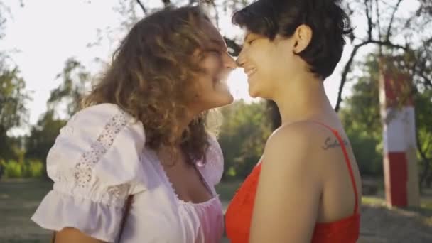Portret dwóch pięknych kobiet śmiać się i tarcie nosy zbliżenie. Piękny lesbijki para ciesząc zachód słońca razem. Romantyczna Data, miłość, relacja przetargowa — Wideo stockowe