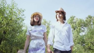 Sevimli çift parkta ya da bahçede el ele tutuşarak ve konuşuyor yürüyüş. Uzun saçlı ve güzel bir kadın dışarıda birlikte vakit geçiriyor. Retro tarzı. Alt görünüm